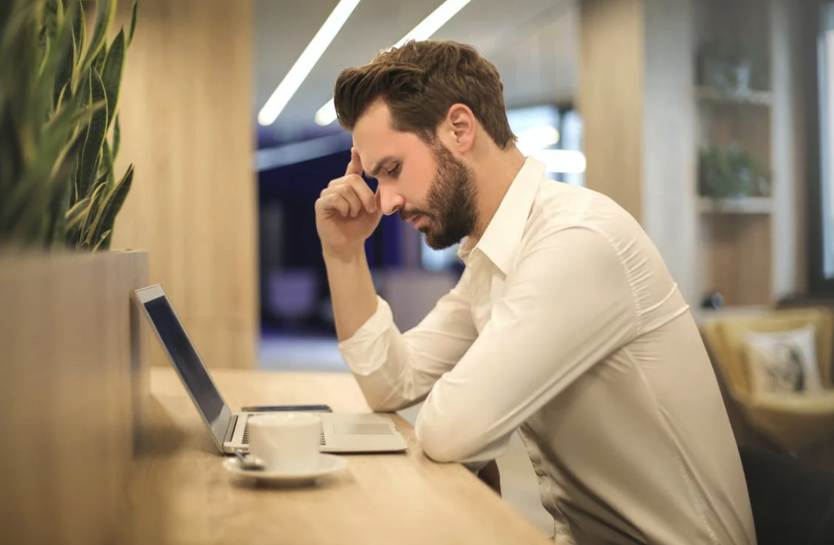 Stressed out man sitting at his desk on a laptop