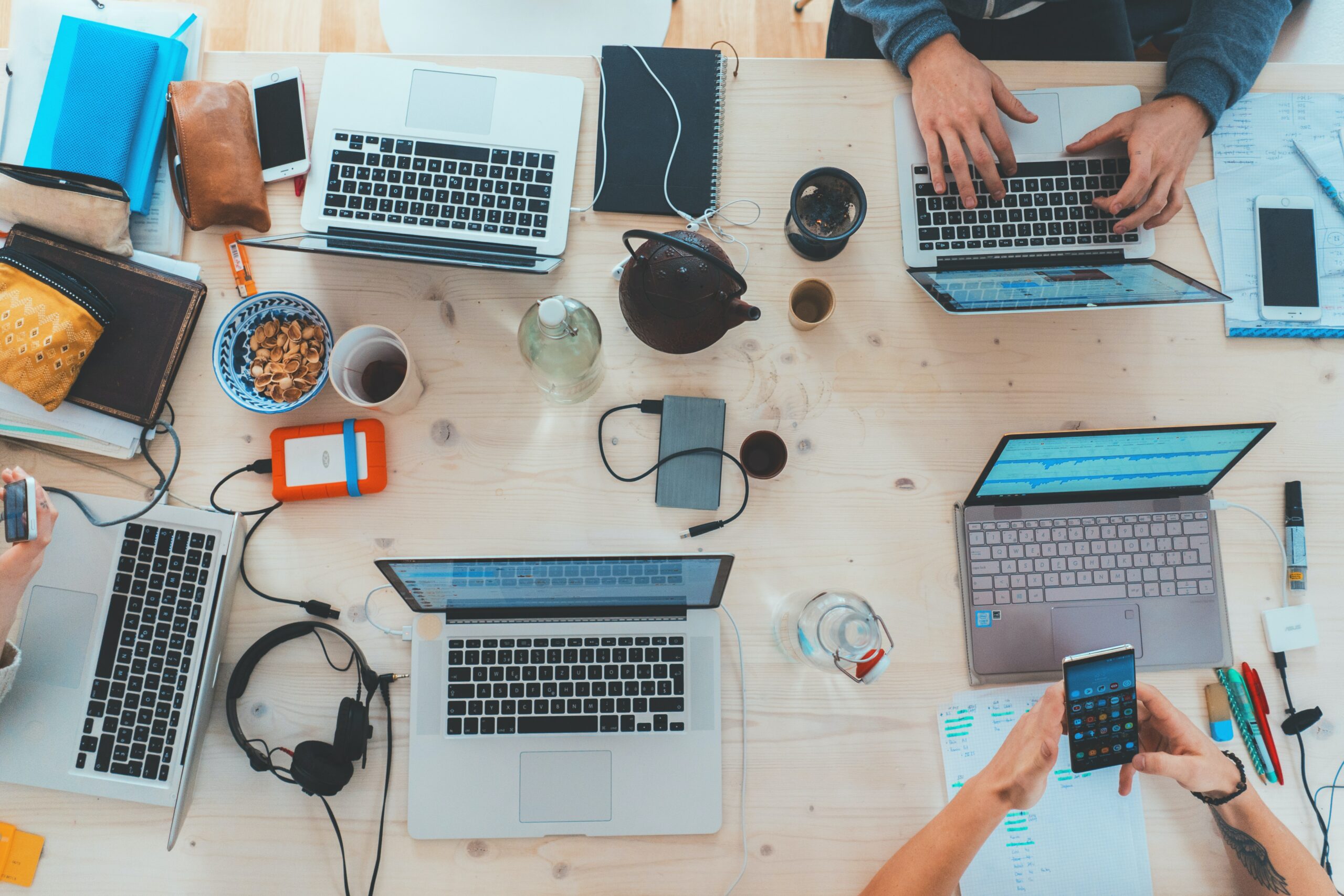 A photo of people's hands and computers. Team collaboration.